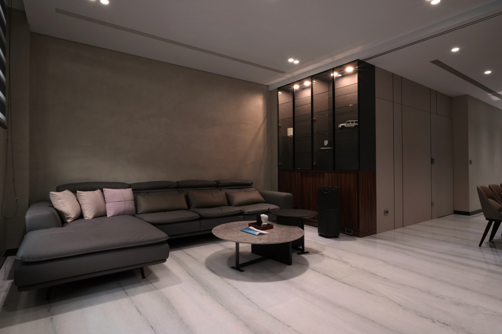 客廳牆面以低調、霧面質感的淺灰色特殊塗料作為主體視覺